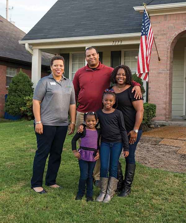 A family poses in front of their new home