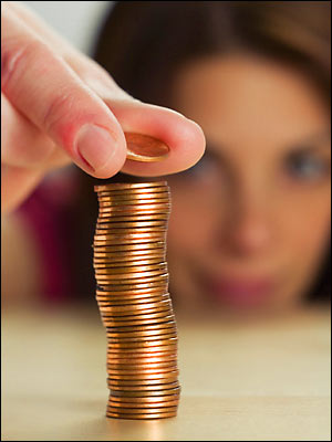 A youth placing a penny on top of a stack of pennies